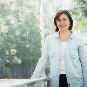 Alex Lyon stands next to a large bush enclosed in glass.