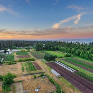 Aerial shot of UBC Farm showing the sky, land and ocean.